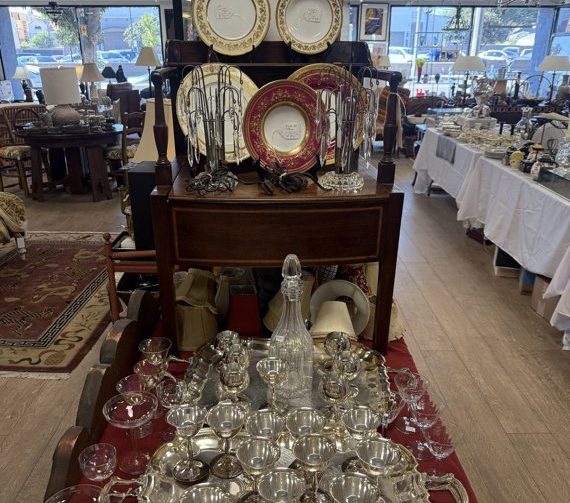 Antique sideboard set with glassware and lamps on the estate sale floor